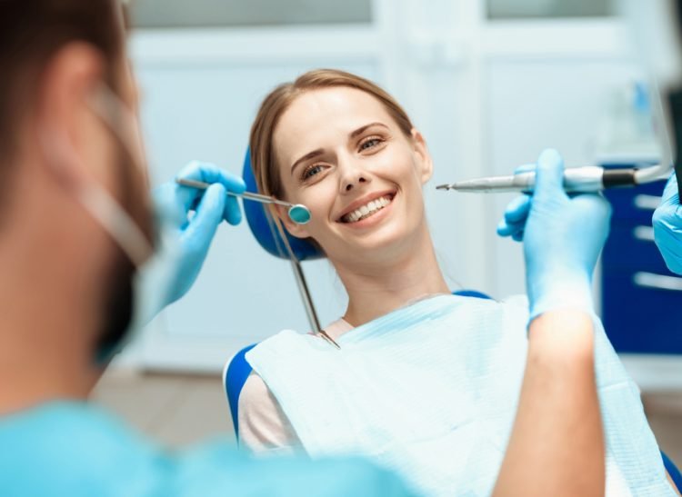 woman-sits-dental-chair-doctors-bowed-her